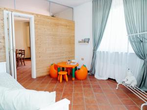 Cette chambre comprend une table et des chaises orange. dans l'établissement Il Vecchio Frantoio Holiday Cottage, à Torrevecchia Teatina