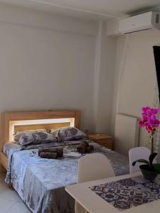 a bedroom with a bed and a table with chairs at Nikola's apartments_King Pyrros in Palio Limani