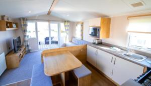 a small kitchen with a table and a counter top at WW265 Camber Sands Holiday Park in Camber