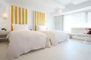 台北的住宿－台北敦化美憬閣酒店，一间白色卧室,配有两张床和窗户