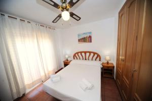 a bedroom with a white bed and a ceiling fan at Adosado Portofino Orangecosta in Benicàssim +15 photos