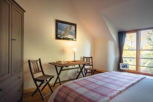 Schlafzimmer mit einem Bett und einem Tisch mit Stühlen in der Unterkunft An ty coz in Beaussais sur Mer