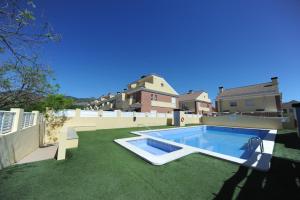 a backyard with a swimming pool and green grass at Adosado Portofino Orangecosta in Benicàssim