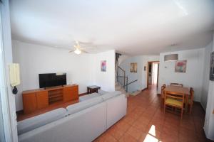 a living room with a couch and a tv at Adosado Portofino Orangecosta in Benicàssim