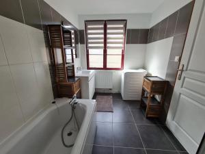 a bathroom with a tub and a sink at Appartement spacieux pour 6 personnes in Saint-Omer