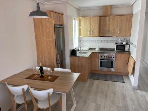 kuchnia z drewnianymi szafkami i stołem z krzesłami w obiekcie Apartamento Fuerteventura w mieście Puerto del Rosario
