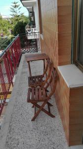 a wooden chair sitting on top of a balcony at Casa RicAdri in Ginosa Marina