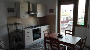 a kitchen with a table and a sink and a stove at Casa RicAdri in Ginosa Marina