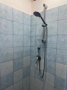 a shower in a bathroom with blue tiles at Lūǧārah - elegante loft in centro storico in Lucera