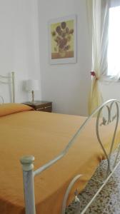 a bedroom with a bed with a yellow blanket at Casa RicAdri in Ginosa Marina