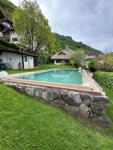 a swimming pool in a yard with a stone retaining wall at Villa Sissi in Laives