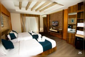 a hotel room with two beds and a television at Hotel Maya Boutique and Apartment, Thamel in Kathmandu