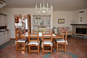 cocina y comedor con mesa de madera y sillas en Villa Irene en Mottola