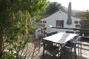 een tafel en stoelen op het balkon van een huis bij La Mareta Family Finca in Agaete