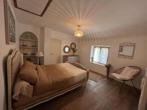 um quarto com uma cama, uma cadeira e uma janela em Jolie maison pleine de charme em Orry-la-Ville