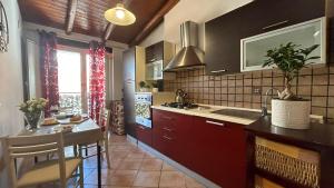 een keuken met rode kasten, een wastafel en een tafel bij A casa di Maria 2 in Catania +26 foto's