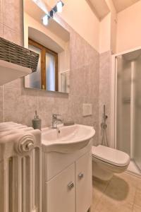 een badkamer met een wastafel, een toilet en een spiegel bij La Casa del Vento - Appartamento Lago - Rebomaholidays in Gargnano