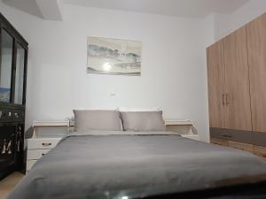 een witte slaapkamer met een bed en een foto aan de muur bij ΟΔΥΣΣΕΙΑ, κοντά σε αεροδρόμιο, λιμάνια και θάλασσες in Keratea