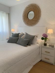 1 dormitorio con 1 cama con espejo en la pared en Apartamento Sanxenxo, en Sanxenxo