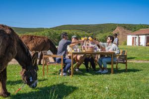 eine Gruppe von Menschen, die mit einem Pferd am Tisch sitzen in der Unterkunft Burro Ville by Host Wise in Portimão