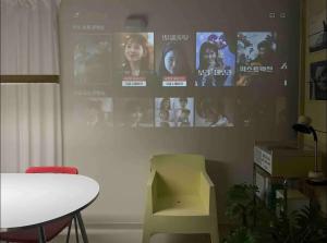 a room with a table and a wall with movie posters at The Ball House in Daegu
