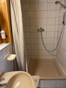 a bathroom with a shower with a tub and a sink at Gästehaus Möschel in Weiler-Simmerberg