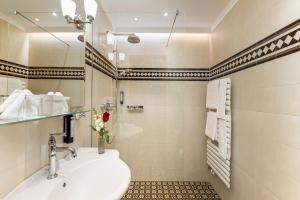 y baño con lavabo y espejo. en Hotel Stefanie - VIENNA'S OLDEST HOTEL en Viena