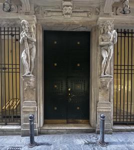 a building with two statues in front of a door at Le Colonne Di San Luca in Genova