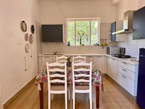 cocina con mesa con sillas, mesa y ventana en The Umri Lansdowne, 4-bedroom homestay, en Lansdowne