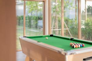 a pool table with balls in a room with a window at Emmarin Villa Pattaya in Nong Prue