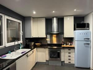 a kitchen with white cabinets and a white refrigerator at Chez Antoine in Saint-Ghislain