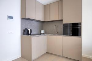 eine Küche mit weißen Schränken und schwarzen Geräten in der Unterkunft Experience Luxury in Lisbon: Embrace Central Comfort in Lissabon