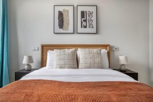 ein Schlafzimmer mit einem Bett mit drei Bildern an der Wand in der Unterkunft Experience Luxury in Lisbon: Embrace Central Comfort in Lissabon
