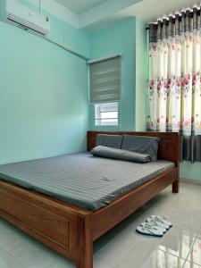 1 dormitorio con cama de madera en una habitación en Nhà nghỉ Hoàn Long (An Giang), en Chau Doc
