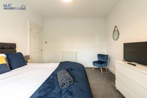 a bedroom with a bed and a flat screen tv at River Teviot in Hawick