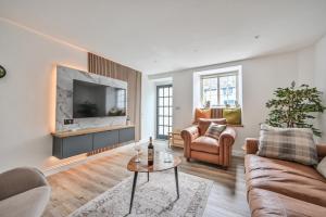 un soggiorno con un divano e una TV di 1 Bake Cottage Serenity - Premium Coastal Retreat in Looe, Cornwall a Looe
