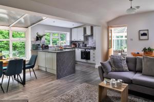 ein Wohnzimmer und eine Küche mit einer Couch und einem Tisch in der Unterkunft Finest Retreats - Nant Cottage in Llangelynin