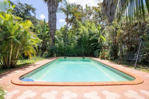 a swimming pool in a yard with palm trees at GIGIRI DRIVE::2BR EXQUISITELY FURNISHED PENTHOUSE in Nairobi