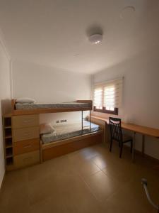 ein Schlafzimmer mit einem Etagenbett mit einem Stuhl und einem Schreibtisch in der Unterkunft Las Olas in Puerto del Rosario