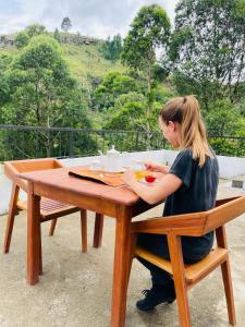 a woman sitting at a table with a plate of food at Rock n Fall Nature Resort in Ella