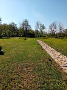 a stone path in a field with trees in the background at Villa River and Sky in Bihać