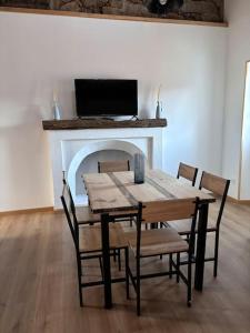 mesa de comedor con sillas y chimenea en chez lulu Appartement cosy. en Cozzano