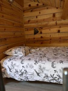 Cama en habitación con pared de madera en chez lulu Appartement cosy. en Cozzano