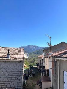 an alley between two buildings with mountains in the background at chez lulu Appartement cosy. in Cozzano +2 photos