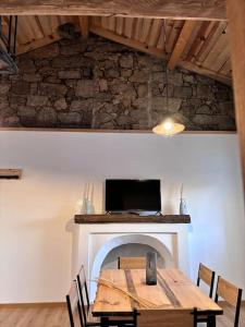 a dining room with a table and a fireplace at chez lulu Appartement cosy. in Cozzano
