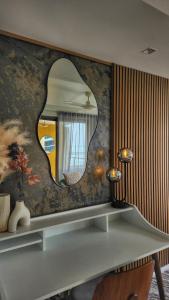 a mirror on a wall above a desk at Wharf-view Waterfront Apartment in Darwin
