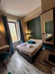 una camera d'albergo con letto e specchio di Hotel Domus Tiberina a Roma