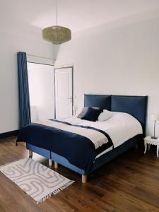 - une chambre avec un lit doté d'une tête de lit bleue dans l'établissement CHATEAU D'APREMONT, à Apremont