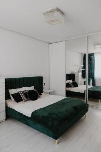 una camera da letto con un grande letto con una coperta verde di AH Zimná a Košice