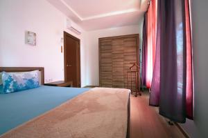 um quarto com uma cama azul e uma porta de madeira em Cozy apartments in Bulduri em Jūrmala
